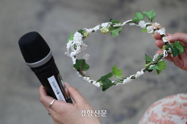 5·18 민주화운동 당시 계엄군 등에 의해 성폭력 피해를 입은 피해자가 지난달 28일 광주광역시 전남대학교 김남주홀에서 ‘5·18 민주화운동진상규명조사위원회’ 주최로 열린 간담회에서 마이크와 머리띠를 들고 있다. 정효진 기자