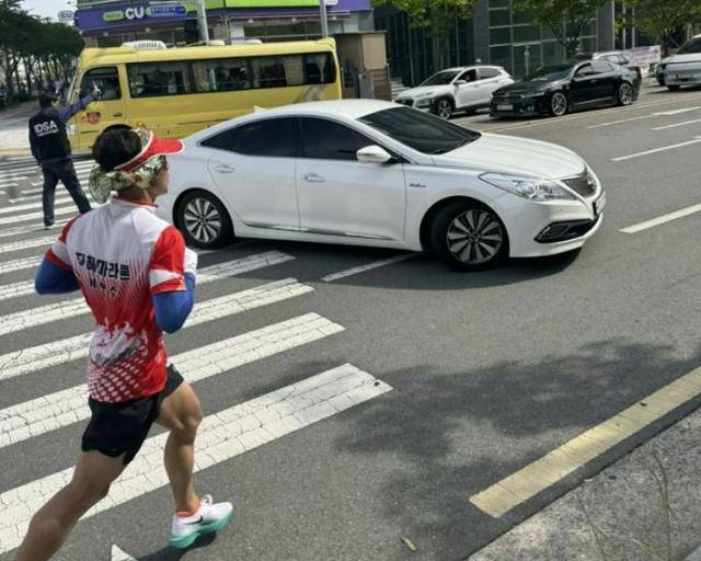 지난달 28일 부산 기장읍 오시리아 물음표공원에서 열린 제6회 기장바다마라톤대회. 참가자들이 뛰는 앞에서 차량이 유턴하고 있다. 이영하씨 제공