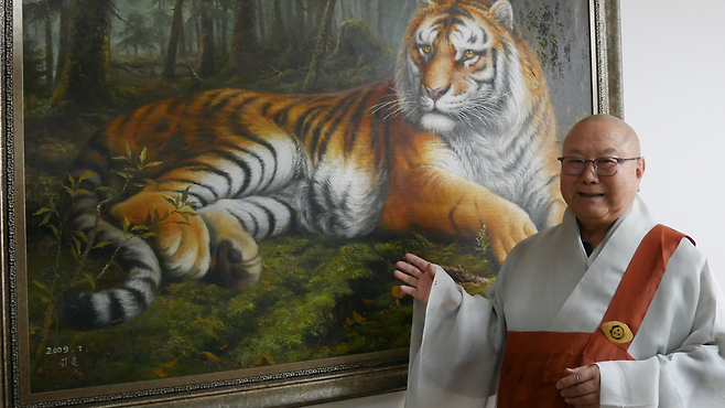 한국 조계종 원로의원 법타스님이 북한에서 직접 구매한 그림에 대해 설명하고 있다
