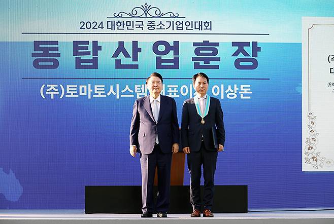 (왼쪽부터) 윤석열 대통령과 토마토시스템 이상돈 대표이사가 지난 23일 '2024 대한민국 중소기업인 대회'에서 동탑산업훈장을 받은 뒤 기념촬영을 하고 있다. /사진제공=토마토시스