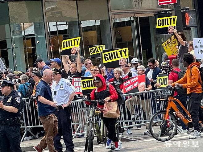 31일(현지시간) 뉴욕 맨해튼 트럼프타원 앞에서 트럼프 반대 시위자들이 ‘유죄’, ‘조심해요 여기 중범죄자가 있어요’, ‘틱톡, (당신의) 시간은 끝났다’는 푯말을 들고 목소리를 높이고 있다. 뉴욕=김현수 특파원 kimhs@donga.com