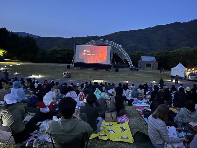 지난 6일 덕유산국립공원 대집회장에서 열린 무주산골영화제 야외상영을 앞두고 환경 관련 짧은 다큐멘터리를 보고 있는 관객들. 김은형 기자