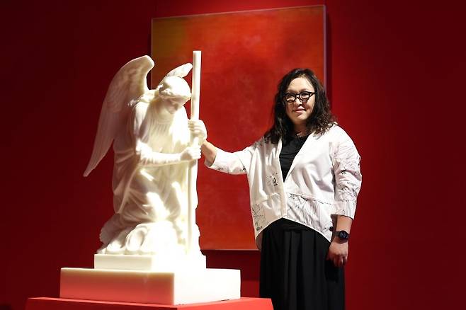 비누를 재료로 독특한 작품세계를 펼쳐온 조각가 신미경이 천사를 주제로 한 자신의 작품 앞에서 포즈를 취하고 있다. 사진=뉴시스