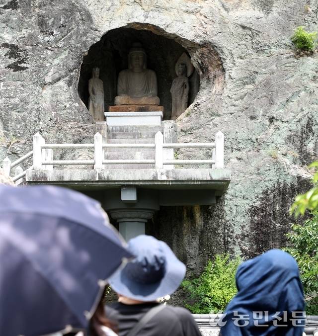 참가자들이 군위 삼존석굴 안 불상의 염화미소를 감상하고 있다.