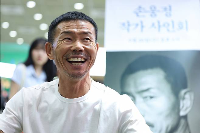 (서울=뉴스1) 신웅수 기자 = 축구선수 손흥민의 아버지인 손웅정 SON축구아카데미 감독이 26일 서울 강남구 코엑스에서 열린 2024 서울국제도서전에서 열린 사인회에서 미소짓고 있다. 손 감독은 소속 유소년 선수에 대한 욕설과 체벌 등 아동학대 혐의로 검찰 조사를 받고 있다. 2024.6.26/뉴스1