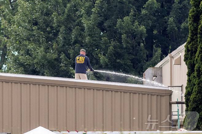 14일(현지시간) 미국 펜실베이니아주 버틀러에서 도널드 트럼프 공화당 후보를 저격한 총격 용의자 매튜 크룩스가 사살당한 현장을 FBI 직원이 물로 청소하고 있다. 2024.07.14 ⓒ 로이터=뉴스1 ⓒ News1 정지윤 기자