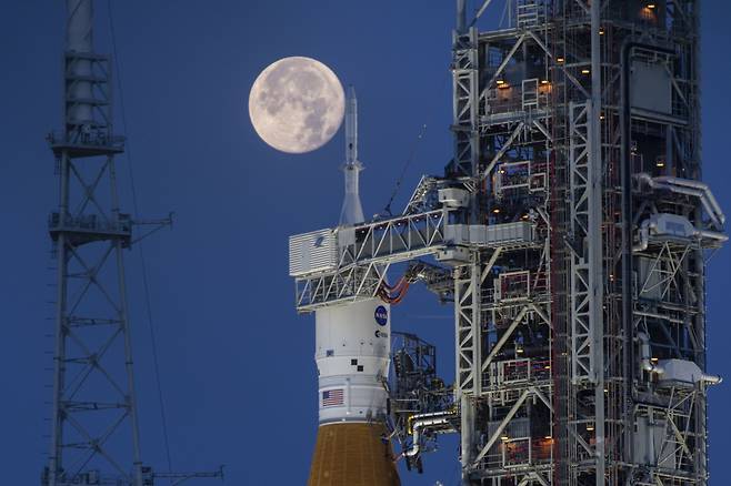 2022년 6월 14일 미 항공우주국(NASA) 케네디 우주센터의 아르테미스 대형 로켓 '스페이스론처시스템(SLS)'과 오리온 우주선 뒤로 보름달이 뜬 모습./NASA