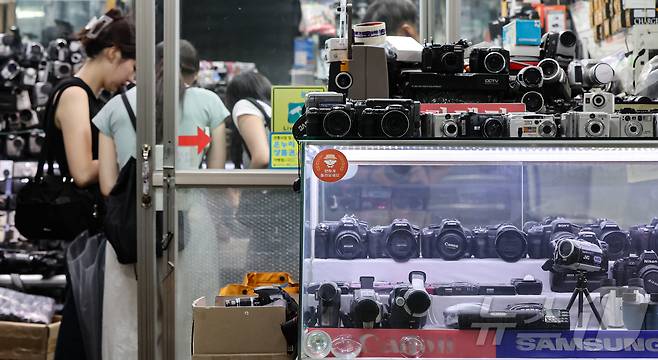 22일 서울 종로구 세운상가 내 중고카메라 매장에서 손님들이 구형 디지털카메라를 살펴보고 있다. 2024.7.22/뉴스1 ⓒ News1 김도우 기자