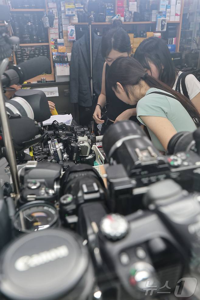 22일 서울 종로구 세운상가 내 중고카메라 매장에서 손님들이 구형 디지털카메라를 살펴보고 있다. 2024.7.22/뉴스1 ⓒ News1 김도우 기자