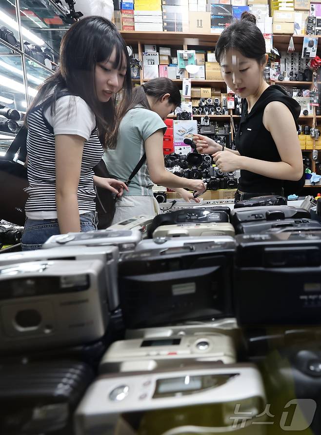 22일 서울 종로구 세운상가 내 중고카메라 매장에서 손님들이 구형 디지털카메라를 살펴보고 있다. 2024.7.22/뉴스1 ⓒ News1 김도우 기자