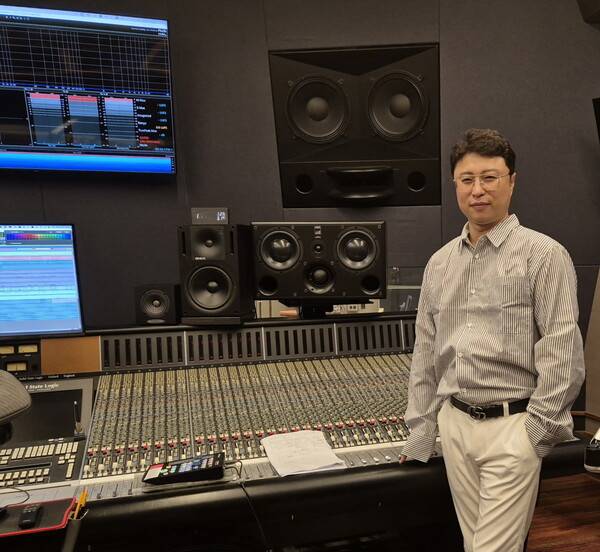 최남진 감독이 국내에 단 한 대 밖에 없는 SSL 9000K 앞에서 포즈를 취하고 있다.