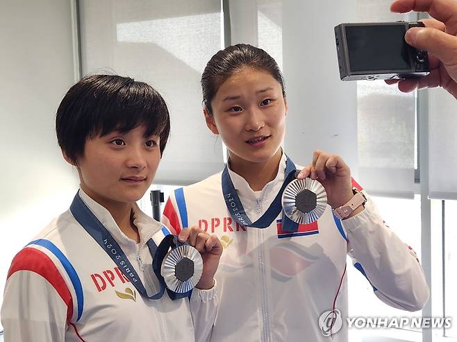 은메달 든 북한 김미래-조진미 (파리=연합뉴스) 하남직 기자 = 2024 파리 올림픽 다이빙 여자 싱크로 10m 플랫폼에서 은메달을 차지한 북한 김미래와 조진미가 31일 프랑스 파리 아쿠아틱센터에서 메달을 들고 기념촬영을 하고 있다. 2024.7.31 jiks79@yna.co.kr