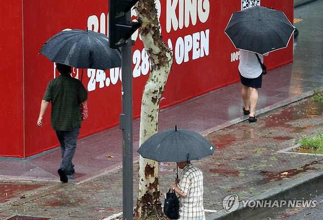 소나기 내리는 거리 (광주=연합뉴스) 조남수 기자 = 전국 대부분 지역에 폭염경보가 발효된 5일 광주 서구 치평동에서 시민들이 내리는 소나기에 우산을 쓰고 걷고 있다. 2024.8.5 iso64@yna.co.kr