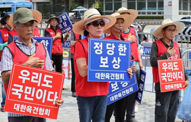 지난 1일 오후 서울 용산구 대통령실 인근에서 대한육견협회 주최로 열린 '개 식용 종식법' 관련 기자회견에서 참석자들이 국민의례를 하고 있다. <연합뉴스>