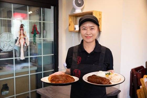 캠프 캐럴 앞 식당 중에 가장 오래된 한미식당은 돈까스, 햄버거 등이 맛있다. 2대 사장인 유경미 사장이 대표 메뉴인 슈니첼과 코던 블루를 들어보이고 있다.