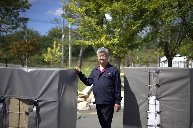 박정구 주영피앤에스 대표가 친환경 팔레트 포장재 ‘에코번들’과 함께 사진 촬영을 하고 있다. 주영피앤에스