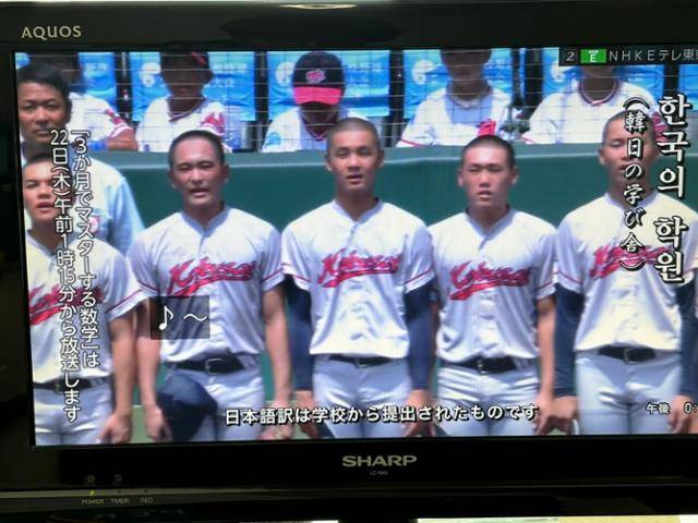 재일 한국계 민족학교인 교토국제고 선수들이 21일 효고현 니시노미야시 한신고시엔구장에서 열린 여름 고시엔 본선 4강전에서 승리한 뒤 한국어 가사로 시작하는 교가를 부르고 있다. 사진은 일본 NHK방송 중계 화면을 촬영한 것으로, NHK가 교토국제고 교가 한국어·일본어 가사를 자막으로 내보내는 모습이다. 도쿄=류호 특파원