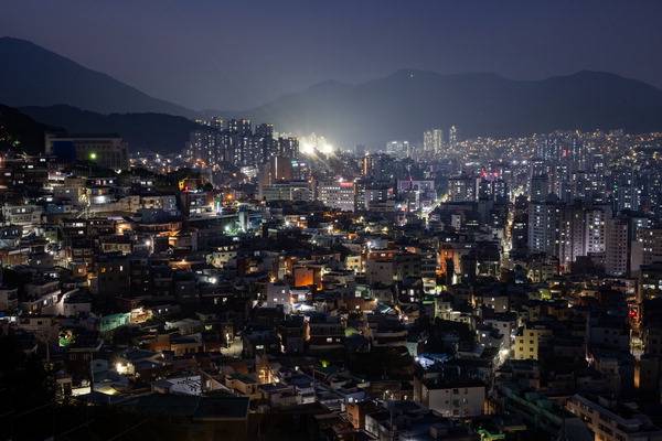 부산이 빈집으로 멍들고 있다. 국제신문 창간 77주년 기획시리즈 ‘부산 빈집 팬데믹’을 시작하면서 빈집이 있으면 주변에 빈집은 더욱 늘어난다는 사실을 확인했다. 사진은 지난 주말 밤 서구 천마산로에서 내려다본 초장동 주택가 전경. 빈집으로 인해 깜깜한 초장동 뒤로 대신동 일대의 구덕운동장 및 아파트가 환한 조명을 밝히고 있다. 이원준 기자 windstorm@kookje.co.kr