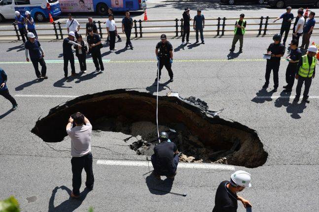 지난달 29일 오전 서울 서대문구 연희동 성산로에서 발생한 땅꺼짐 사고 현장에서 경찰과 소방 관계자들이 사고 폭을 측정하고 있다.ⓒ연합뉴스