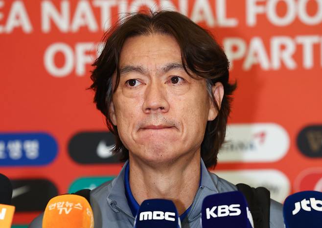 북중미 월드컵 3차 예선 오만과의 원정경기에서 승리를 거둔 축구 국가대표팀 홍명보 감독이 12일 오후 인천국제공항 제1여객터미널을 통해 입국해 취재진 질문을 듣고 있다. 인천공항 | 연합뉴스
