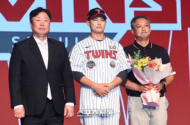 서울고 투수 김영우(가운데)가 11일 서울 송파구 롯데호텔 월드 크리스탈 볼룸에서 열린 ‘2025 KBO 신인 드래프트’에서 전체 10순위로 LG에 지명된 뒤 차명석 단장(왼쪽), 아버지와 함께 취재진을 향해 포즈를 취하고 있다. 2024. 9. 11. 박진업 기자 upandup@sportsseoul.com