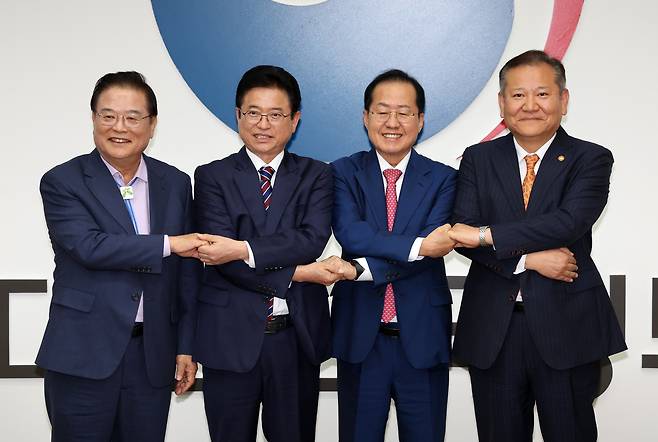 우동기(왼쪽부터) 지방시대위원장, 이철우 경북도지사, 홍준표 대구시장, 이상민 행정안전부 장관이 21일 오후 서울 종로구 정부서울청사에서 열린 대구·경북 통합 관련 4자 회동에서 합의문에 서명 후 기념촬영을 하고 있다. /연합뉴스