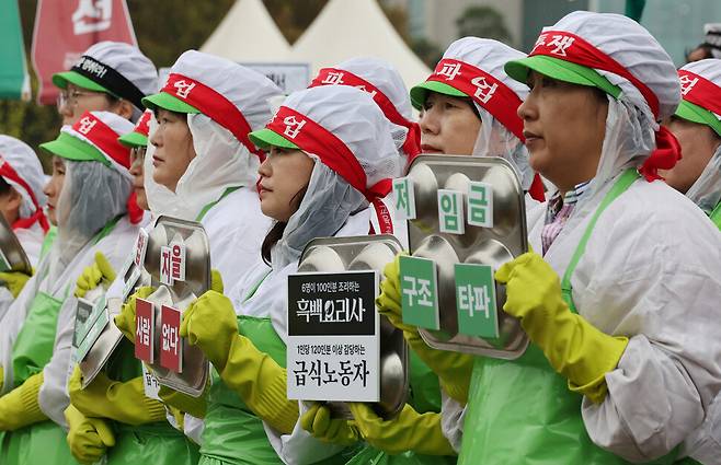 급식실에서 사용하는 모자와 장갑을 착용한 학교 급식노동자들이 총파업을 알리는 머리띠를 한 채 급식판을 들어보이고 있다. 신소영 기자 viator@hani.co.kr