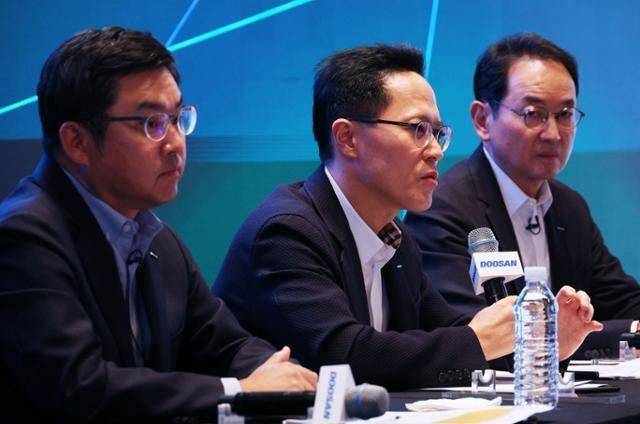 박상현 두산에너빌리티 대표(가운데)가 지난 21일 서울 중구 플라자호텔에서 열린 두산에너빌리티-두산로보틱스 분할합병 건 기자간담회에서 취재진 질문에 답하고 있다. 왼쪽부터 류정훈 두산로보틱스 대표, 박 대표, 스캇 박 두산밥캣 부회장. ⓒ연합뉴스