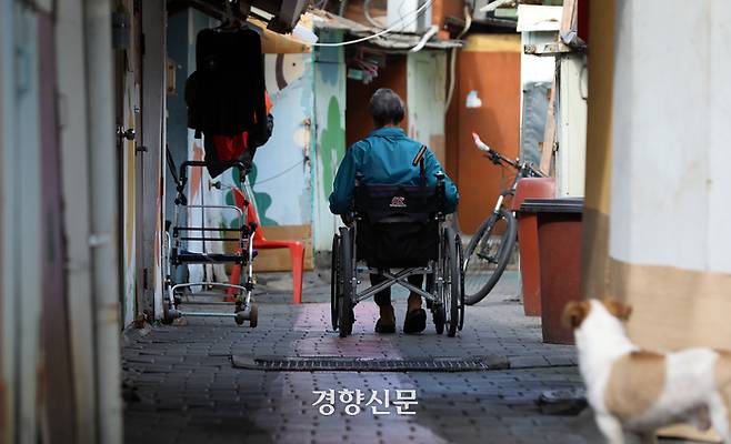 정부가 내년도 예산안을 발표한 8월 27일 서울 영등포구 쪽방촌에서 한 어르신이 휠체어를 타고 이동하고 있다. 권도현 기자