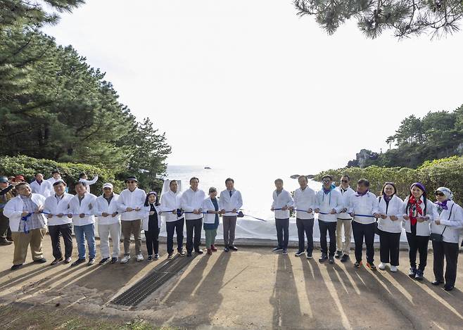 Participants at the Jeju Olle Trail 8 Route: ASEAN-Korea Olle unveiling ceremony, including Korea-ASEAN Center Secretary-General Kim Jae-shin (11th from left), Jeju Island Gov. Oh Young-hun (10th from left), actor Ryu Seung-ryong (13th from left) and ambassadors representing Southeast Asian countries, pose for a photo in front of a concrete bench to commemorate the 35th anniversary of dialogue relations between South Korea and the Association of Southeast Asian Nations on Friday. (Korea-ASEAN Center)
