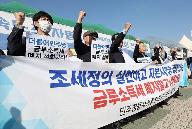 민주평등사회를 위한 전국교수연구자협의회가 13일 오후 서울 영등포구 국회 앞에서 연 금투세 도입 촉구 성명 기자회견에서 참가자들이 구호를 외치고 있다. 연합뉴스