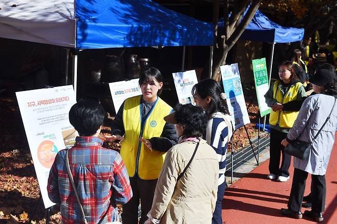경기 동두천시 소요산에서 열린 하나님의 교회 ‘희망의 숲’ 캠페인에서 봉사자들이 사막화의 심각성과 해법을 담은 패널 전시를 하는 모습. 동두천을찾은 시민들이 봉사자들의 설명을 유심히 듣고 있다.