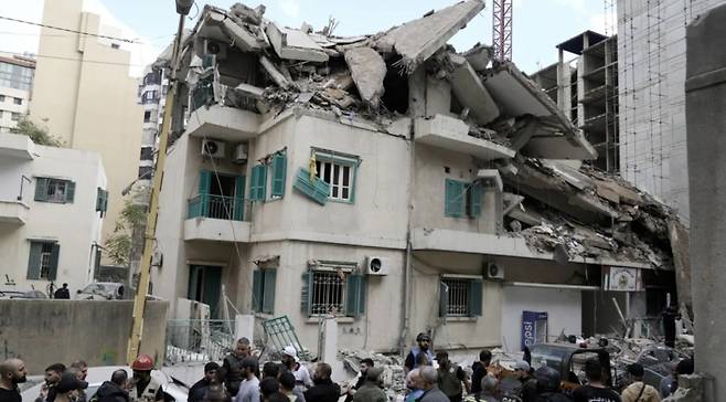 17일(현지시간) 레바논 주민과 구조대원들이 이스라엘군의 베이루트 중심부 공격으로 무너진 건물을 살펴보고 있다. /AP=뉴시스