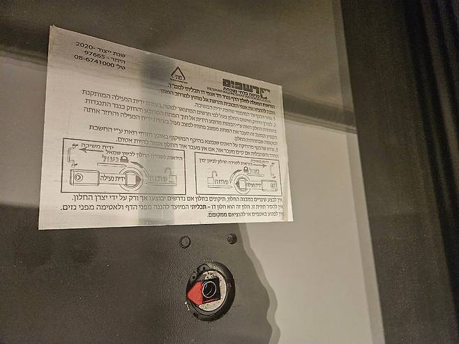 ‘마마드’로 설계된 텔아비브 아파트 침실의 철제 창문을 닫은 모습. 하단의 개폐 장치 위에 히브리어로 사용법을 적은 안내문이 붙어 있다./김지원 기자