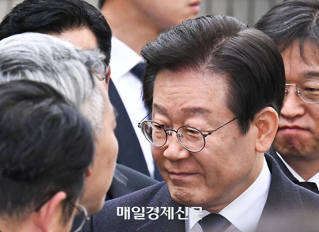 위증교사 혐의 무죄 선고를 받은 이재명 더불어민주당 대표가 25일 서울 서초동 서울중앙지방법원에서 나온 후 차에 타기 전 의원들에게 인사를 하고 있다. 공동사진취재단