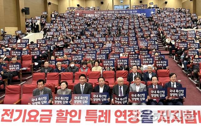 18일 서울 영등포구 국회 의원회관에서 열린 ‘도축장, 전기요금 특례 연장 국회 토론회’’에서 참석자들이 전기요금 할인 특례 연장을 지지한다는 문구를 들어 보이고 있다.