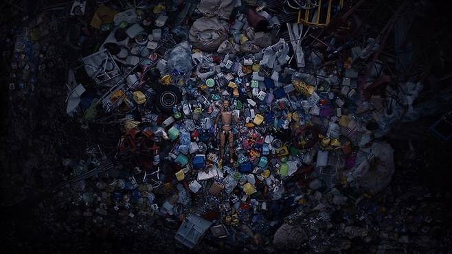 ‘수면안전(Sleep Safety)’영상 중 더미가 쓰레기장 위에 누워있는 모습. 안전성이 검증된 매트리스를 사용하는 모습을 쓰레기 더미 위에 누워있는 장면으로 시각화했다. <N32>