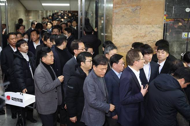 국민의힘 의원들이 7일 오후 서울 여의도 국회에서 열린 의원총회가 끝난 뒤 국회 방호팀의 경호를 받으며 이동하고 있다.(사진 = 뉴시스)