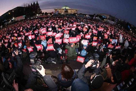 7일 오후 서울 영등포구 여의도 국회의사당 앞에서 열린 '범국민촛불대행진'에서 시민들이 윤석열 대통령의 탄핵소추안 통과를 촉구하며 구호를 외치고 있다. 뉴스1
