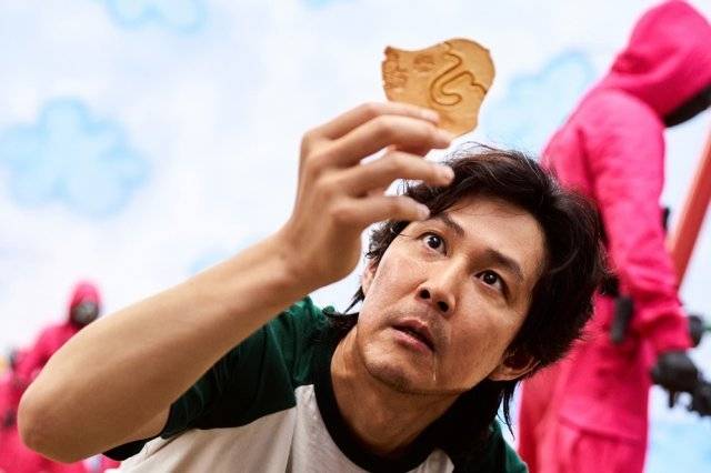 Ki-hun (Lee Jung-jae) plays a game in which he has to carve out a shape from a fragile candy in "Squid Game." (Netflix)