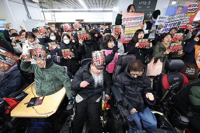 전국장애인차별철폐연대가 24일 오전 서울 종로구 안국역에서 출근길 승강장 다이인(die-in)행동을 열자 활동가와 시민들이 구호를 외치고 있다. 연합뉴스