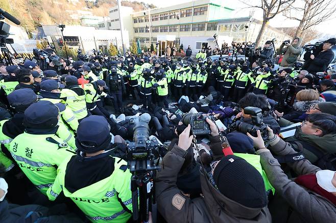 윤석열 대통령에 대한 체포영장 발부 사흘째인 지난 2일 서울 용산구 한남동 대통령 관저 정문 앞 도로에 누워있는 지지자들을 경찰들이 해산시키고 있다. 연합뉴스