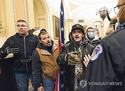미국 의회 폭동 (워싱턴DC AP=연합뉴스 자료사진) 2021년 1월 6일 미국 의회 청사 내 상원 대회의실 앞에서 옛 남부연합 깃발을 든 도널드 트럼프 당시 대통령 지지자들이 청사 경비를 맡은 경찰관들과 대치하고 있다. (AP Photo/Manuel Balce Ceneta, File) 2025.1.6.