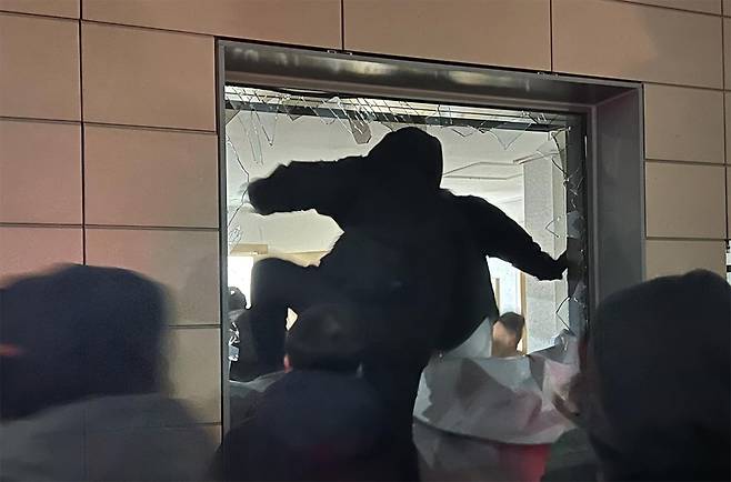 경찰기동대를 밀치고 법원 경내에 들어온 한 시위 참가자가 창문을 부순 뒤 법원 안으로 들어가고 있다. 뉴스1