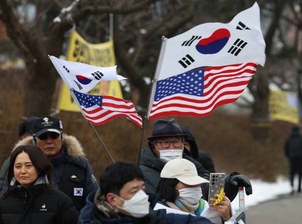 31일 오전 경기도 의왕시 서울구치소 앞에서 윤석열 대통령 지지자들이 태극기와 성조기를 흔들고 있다. 연합뉴스
