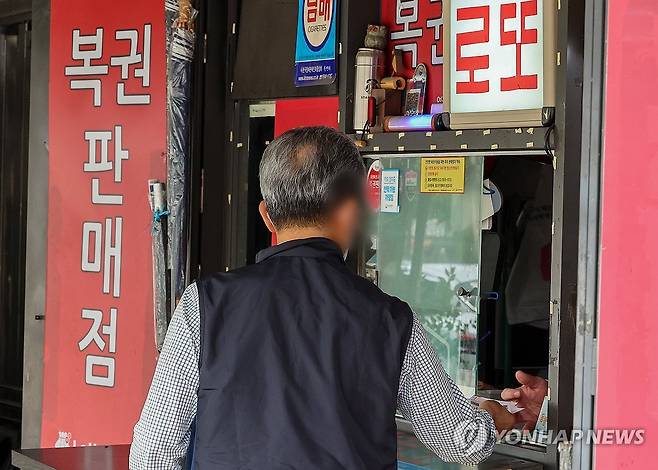 복권 구입 가구 5년 내 최대 (서울=연합뉴스) 서대연 기자 = 올해 1분기 복권 구입한 가구의 비율이 10.1%로 최근 5년간 가장 높았던 것으로 나타난 가운데 30일 오전 한 시민이 서울 시내 한 복권점에서 복권을 구매하고 있다. 2024.5.30 dwise@yna.co.kr