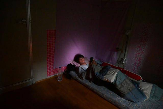 지난달 17일 경기 포천시 비닐하우스 단지에서 자잇씨가 핸드폰을 보고 있다. 신혼 4년차인 아내와 딸이 캄보디아에 있는 자잇씨는 자기 전 비닐하우스 컨테이너 기숙사에 누워 가족들과 영상통화를 한다. 포천=최주연 기자