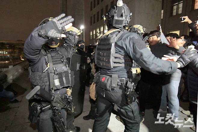 비상계엄이 선포된 12월 4일 자정무렵 서울 여의도 국회 의사당에 진입한 계엄군이 본관 진입을 막으려는 국회 관계자들과 충돌하고 있다. 윤창원 기자