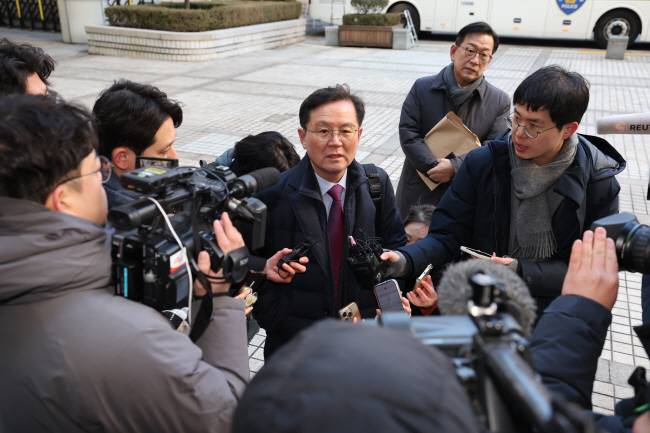 윤석열 대통령 변호인단 윤갑근 변호사가 20일 오전 서울 서초구 서울중앙지법에서 열리는 윤 대통령의 내란 우두머리 혐의 첫 형사재판에 참석하기 위해 법원에 들어서며 취재진의 질문에 답하고 있다. 사진공동취재단