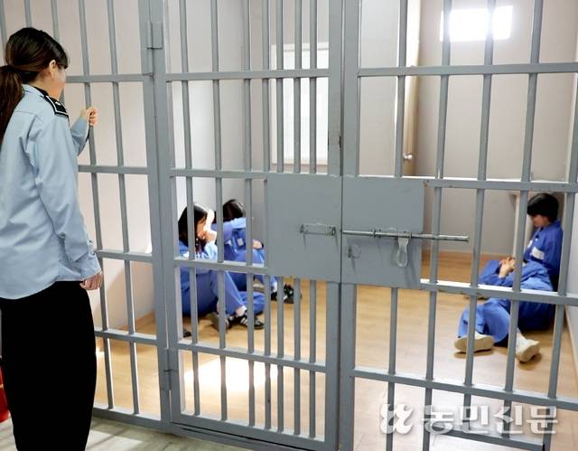 죄수와 교도관 복장으로 갈아입은 관람객들이 유치장 체험을 하고 있다.